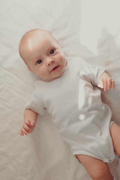 The baby is lying in his crib and looking at the camera Lifestyle A happy child Children's article