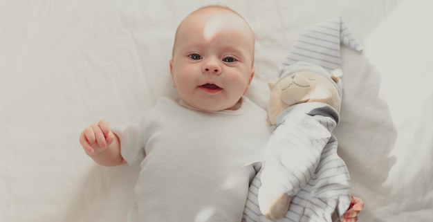 The baby is lying in his crib and looking at the camera Lifestyle A happy child Children's article