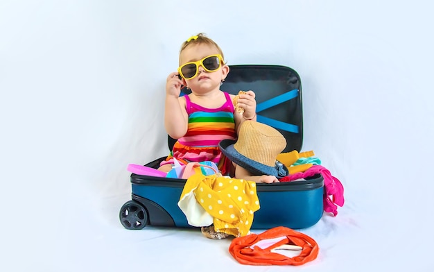 Baby is sitting in a suitcase, getting ready for a travel