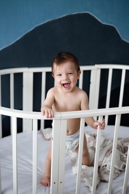 Baby is standing in his crib