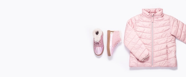 Baby jacket and boots for a girl on a white background. Top view, flat lay. Banner.