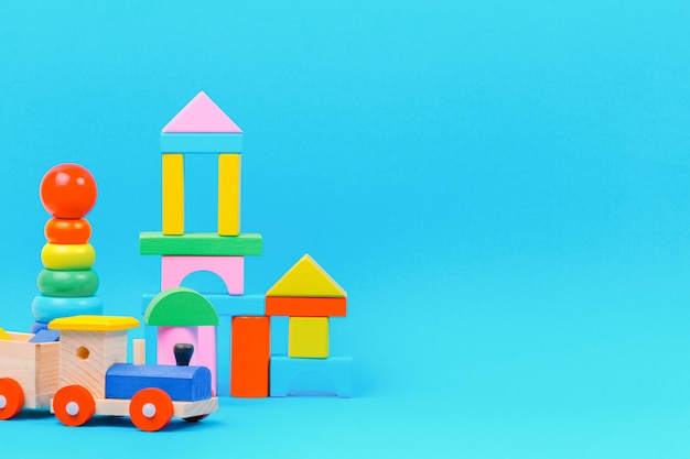 baby kid toy background with colorful wooden toys on light blue background.