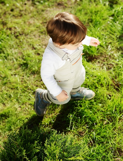 Baby kid walking on the green grass