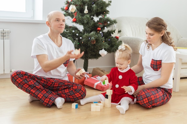 Baby kind met gehoorapparaat en cochleair implantaat plezier met ouders in kerstkamer dove div