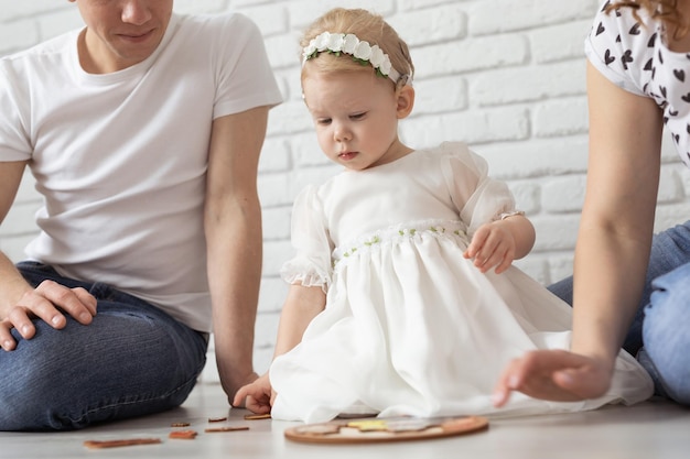Baby kind met gehoorapparaten en cochleaire implantaten speelt met ouders op de vloer Doof en revalidatie en diversiteitsconcept