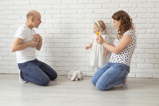 Baby kind met gehoorapparaten en cochleaire implantaten speelt met ouders op de vloer doof en revaliderend