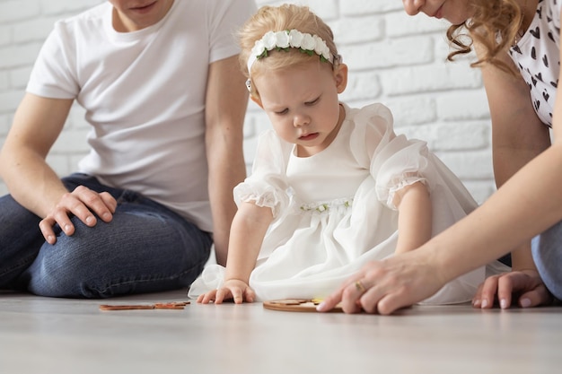 Baby kind met gehoorapparaten en cochleaire implantaten speelt met ouders op de vloer doof en revaliderend