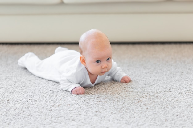 Baby, kinderjaren, mensenconcept - Portret van een kruipende baby op de vloer.