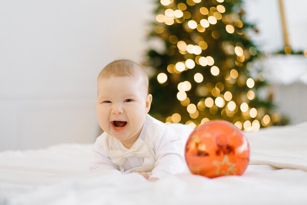 Baby laughs as he lies on the bed