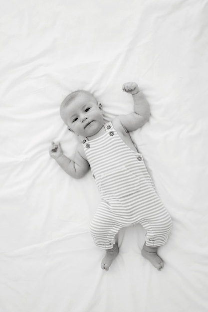 Photo a baby laying on a blanket with a white sheet that says baby