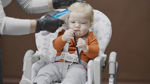 The baby learns comb during first haircut