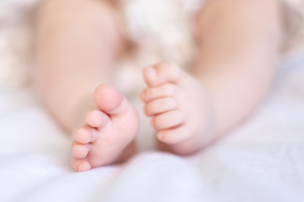 Baby legs of a small baby baby closeup on a white background baby in his crib