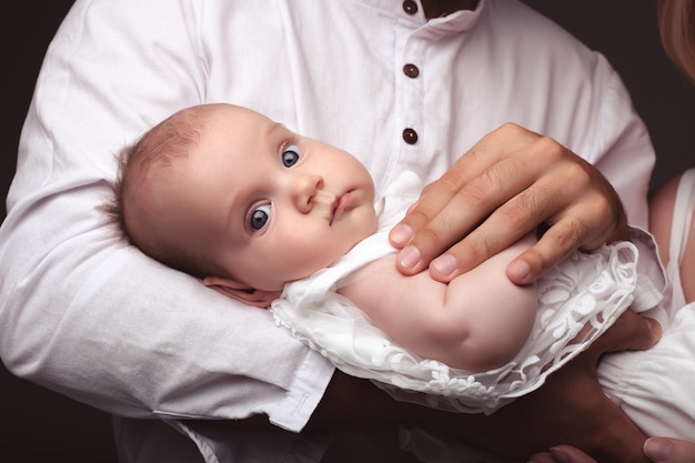 Baby lies in the arms of the parents