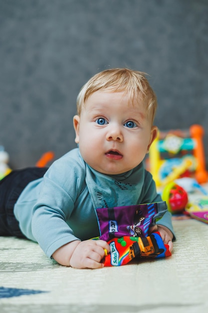 The baby lies on a thermal mat and plays Selfdevelopment of a newborn child Toys for child development