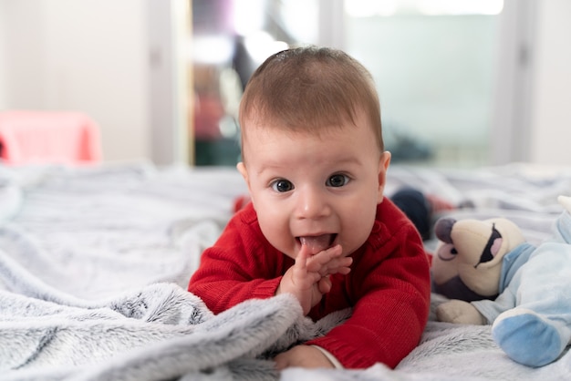 Baby liggend in bed met zijn favoriete pop