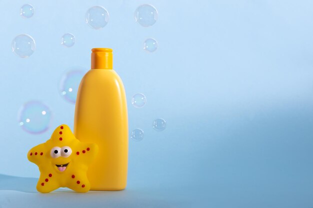 Baby liquid soap or washing gel with yellow star fish and flying soap bubbles childrens hygiene