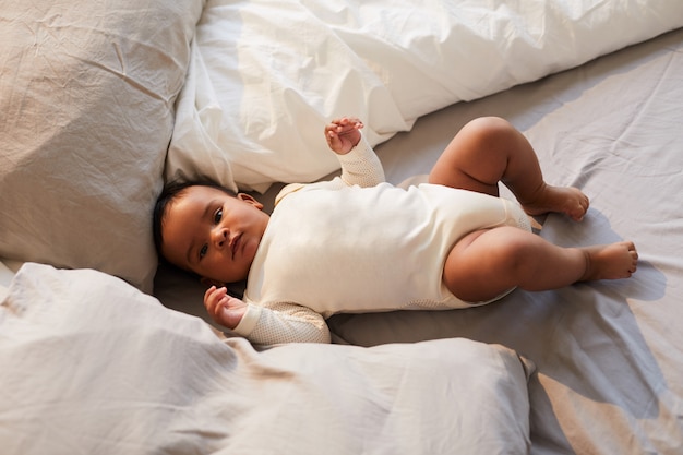 Foto bambino sdraiato tra i cuscini