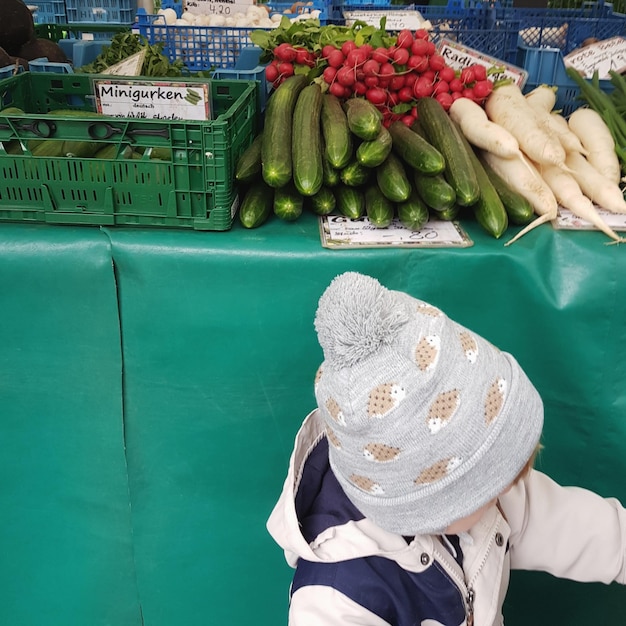 Foto bambino alla bancarella del mercato