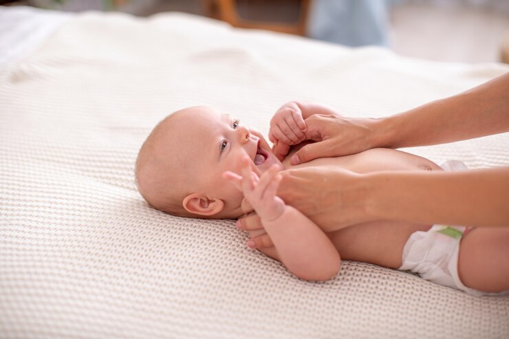 Photo baby massage. a mother gives a massage to her newborn child.