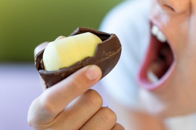 baby meisje bijt een chocolade ei met een plastic speelgoed binnen schadelijk gevaarlijk voedsel voor kinderen