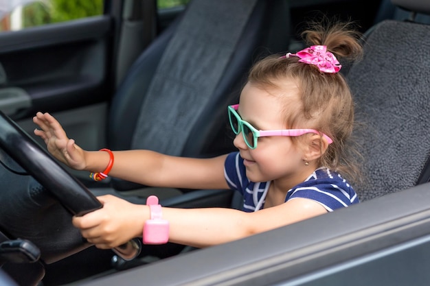 Foto baby meisje kijkt uit het raam van de auto