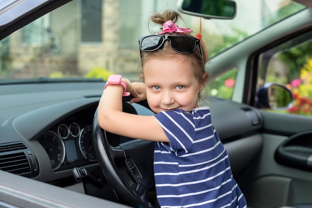 Foto baby meisje kijkt uit het raam van de auto