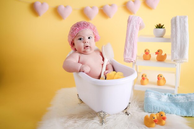 Foto baby meisje poseert en glimlacht in het bad.