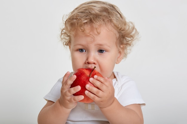 Baby met appel poseren geïsoleerd over wit