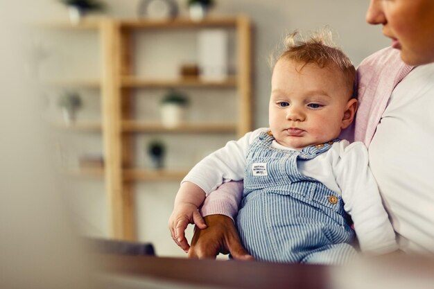 Foto baby met blauwe ogen en zijn moeder die thuis aan het ontspannen is