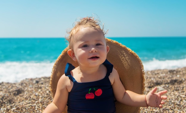 Baby met een hoed op het strand. Selectieve aandacht.