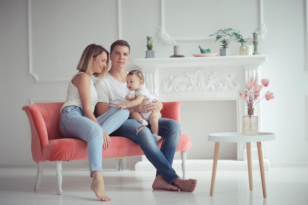 baby met ouders in een gezellig huis / gezond jong gezin moeder vader en baby, geluksglimlach