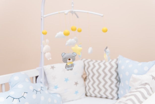 Baby mobile with different toys in the form of animals and\
stars, felt toys in crib