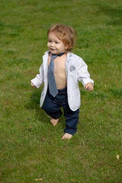 Baby mode grappige kleine zakenman in pak jasje en stropdas schattige kleine baby op de weide fie