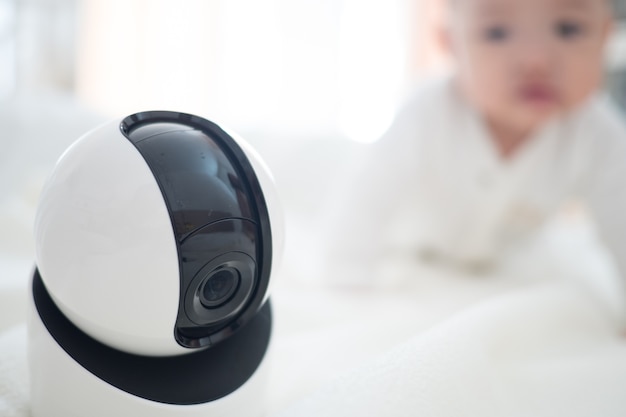 Baby monitor camera with blurred baby background for text space. concept of baby safety