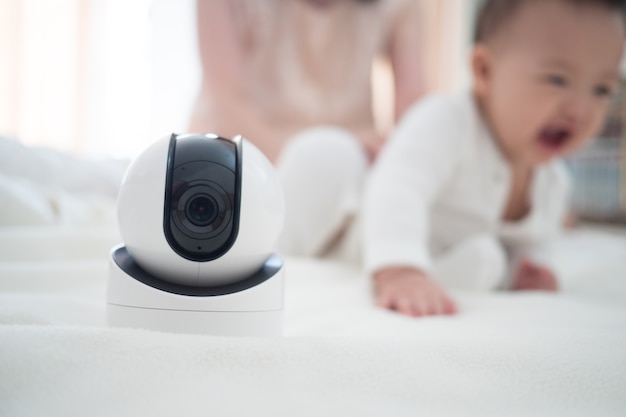 Baby monitor camera with blurred baby background for text space. concept of baby safety