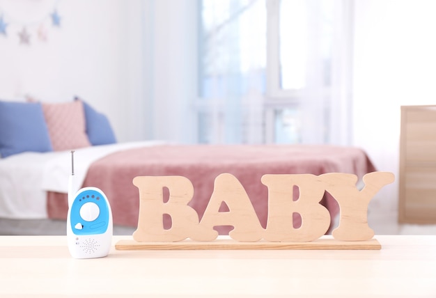 Photo baby monitor and wooden letters on table