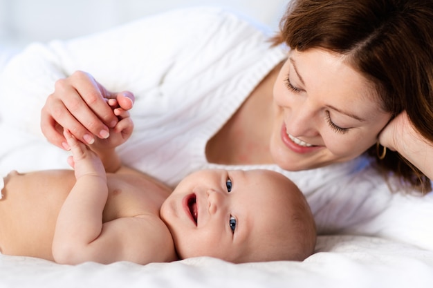 Baby and mother at home in bed. Mom and child.