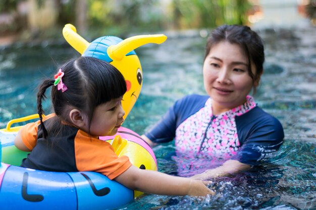 プールで水を再生する赤ちゃんと母