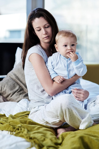 Baby mother and sad with postpartum on bed at family house and problem with stress or being tired Mom newborn and depression with mental health at home with insomnia about child development