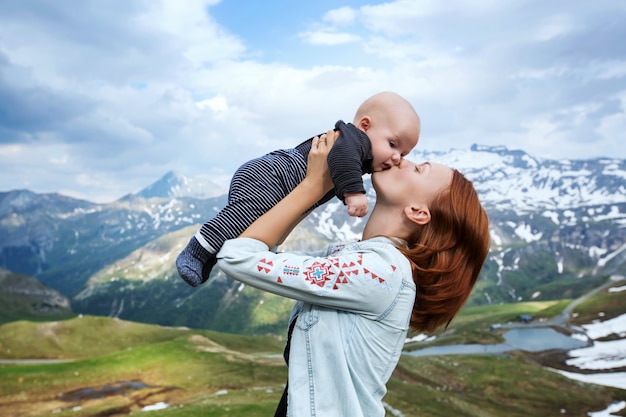 Baby and mother with the Alps mountains in nature in the Backgro