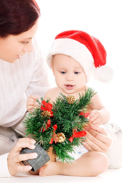 白い壁の上のクリスマスプレゼントと赤ちゃんと母親