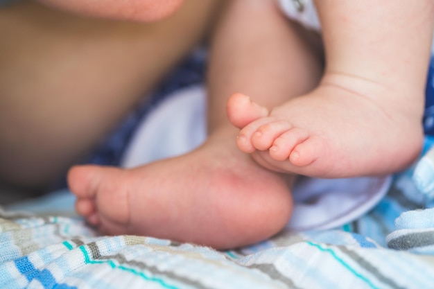 赤ちゃんと新生児のコンセプト 赤ちゃんの毛布に生まれたばかりの赤ちゃんの足のクローズ アップ