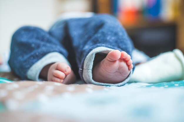 Концепция младенца и новорожденного Крупным планом ноги новорожденного на детском одеяле