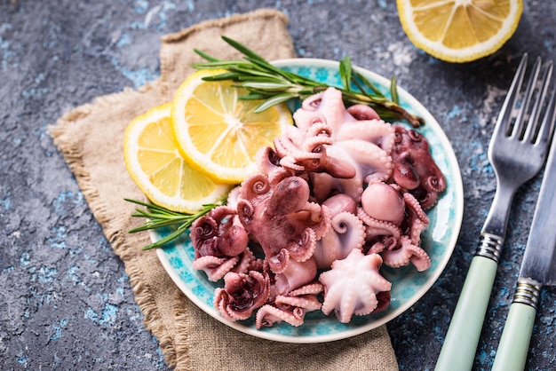 Baby octopus in plate with lemon and rosemary