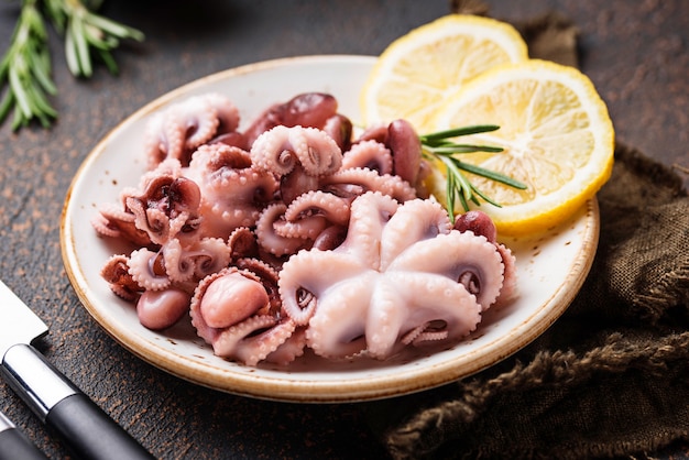 Baby octopus in plate with lemon and rosemary