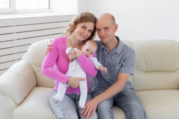 Baby op de handen van ouders op een witte muur.