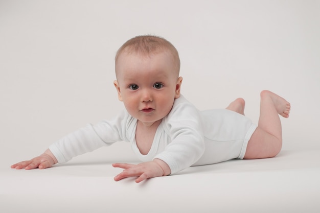 Baby op een witte achtergrond in een witte pyjama