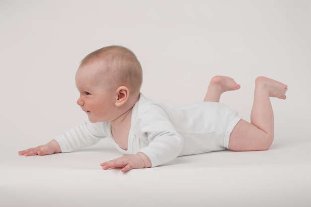 Baby op een witte achtergrond in een witte pyjama