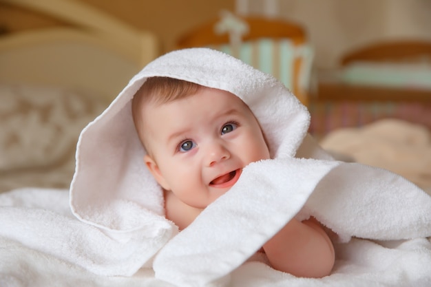 Baby, op het bed in de slaapkamer, handdoek, omslagdoek, glimlach