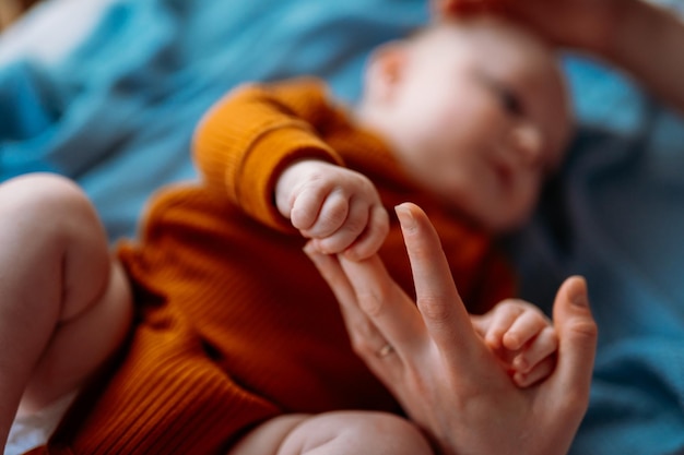 Baby-peuter die de hand van de moeder vasthoudt, de hand van een pasgeboren kind vasthoudt